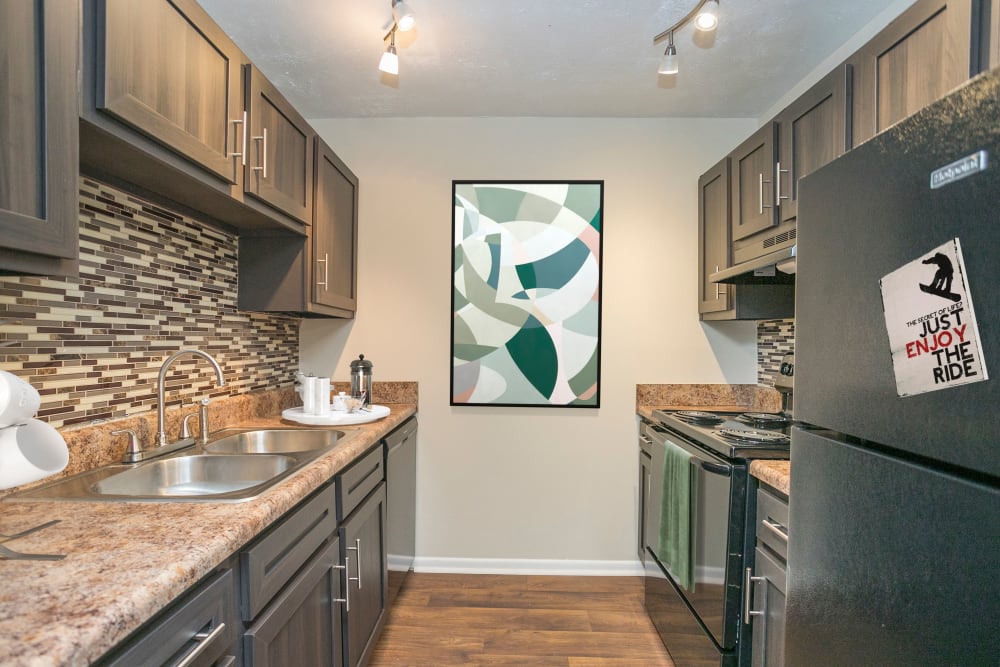 Kitchen featuring black cabinets and tiled backsplash at Candlewood Apartment Homes in Nashville, Tennessee