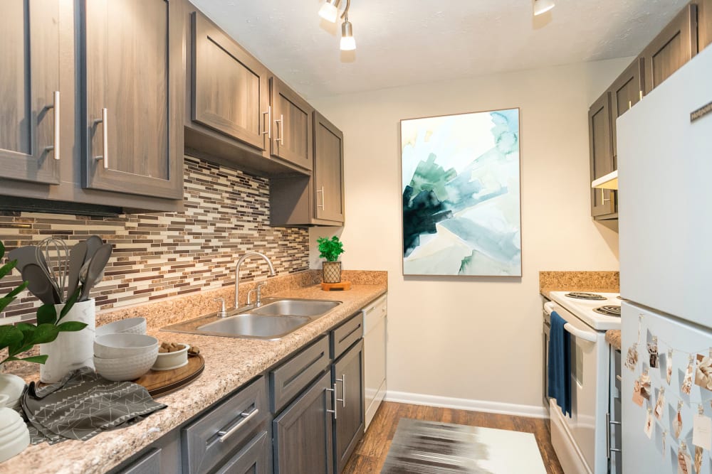 Kitchen with hardwood flooring and stainless steel sink at Candlewood Apartment Homes in Nashville, Tennessee