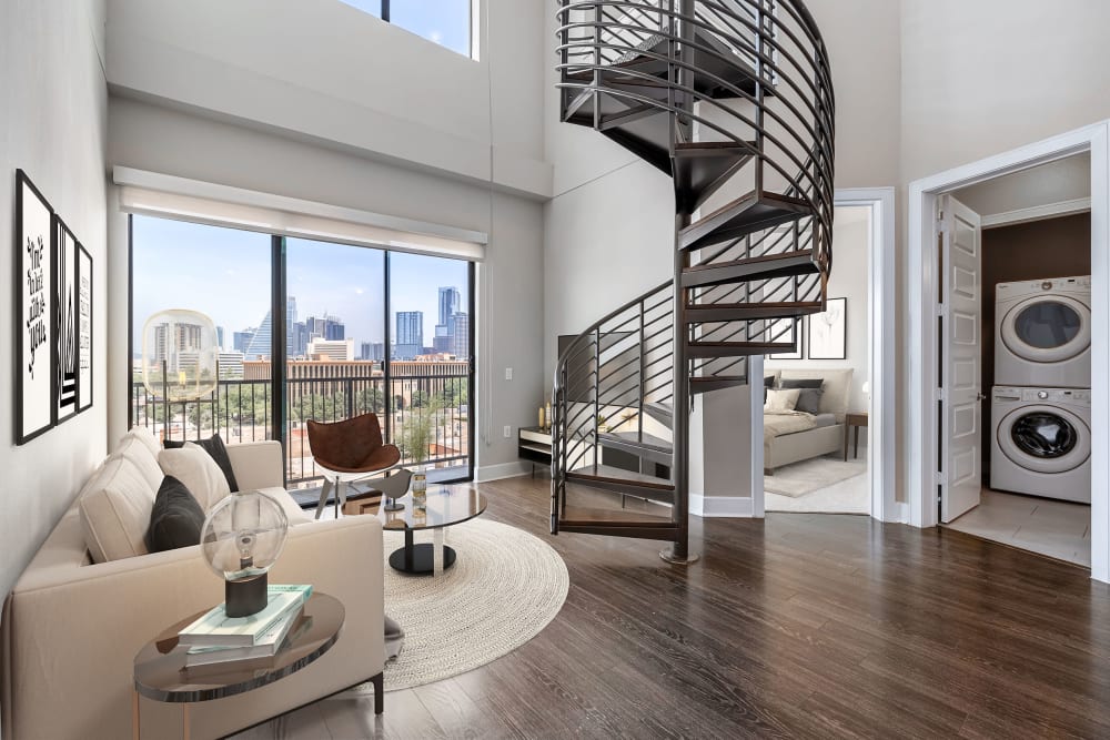 Large staged unit with spiral staircase and a view with downtown Austin at Water Marq in Austin, Texas
