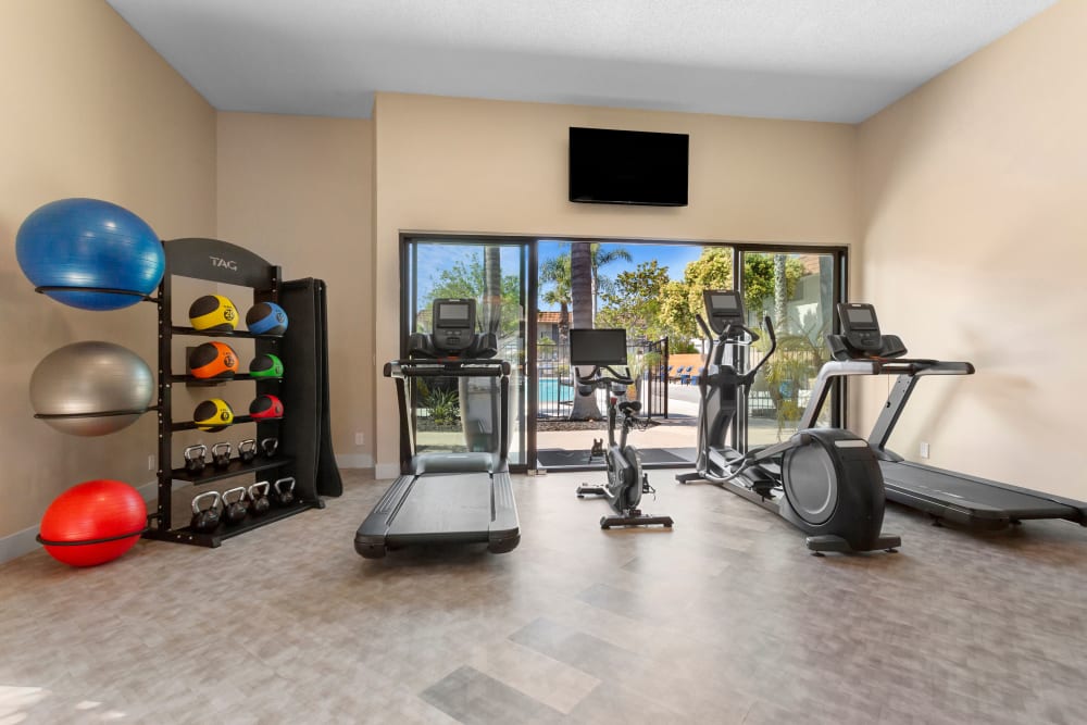 Fitness center with various workout equipment and view of the pool at Terra Camarillo in Camarillo, California