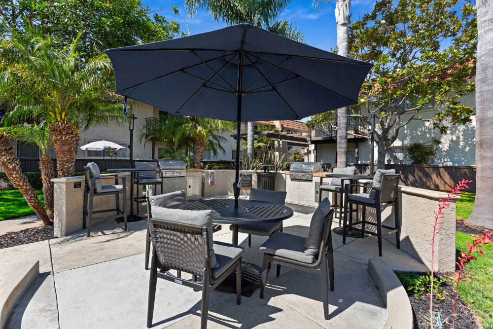 Property barbecue area with seating and shade umbrellas at Terra Camarillo in Camarillo, California