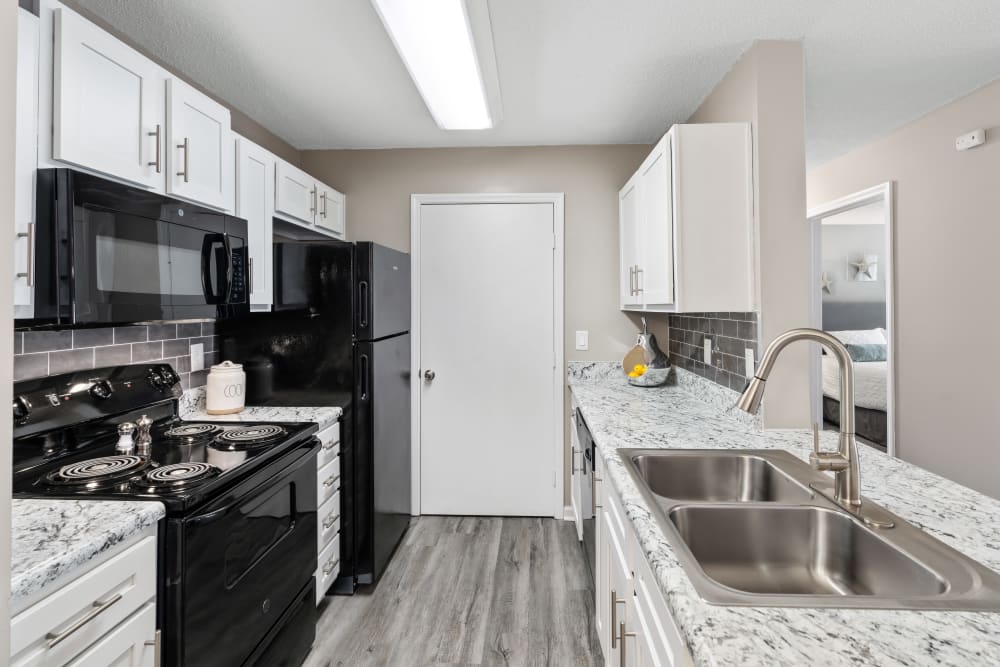 Black and white appliances in an apartment kitchen at Gates at Jubilee in Daphne, Alabama