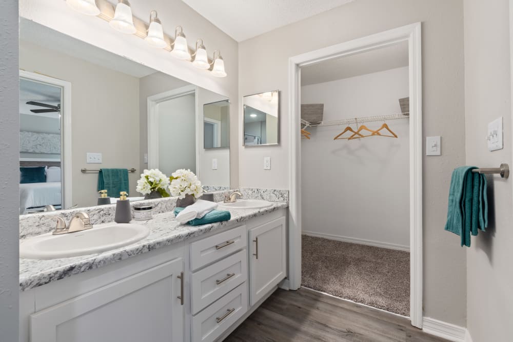 A double sink in an apartment bathroom with an attached closet at Regency Gates in Mobile, Alabama