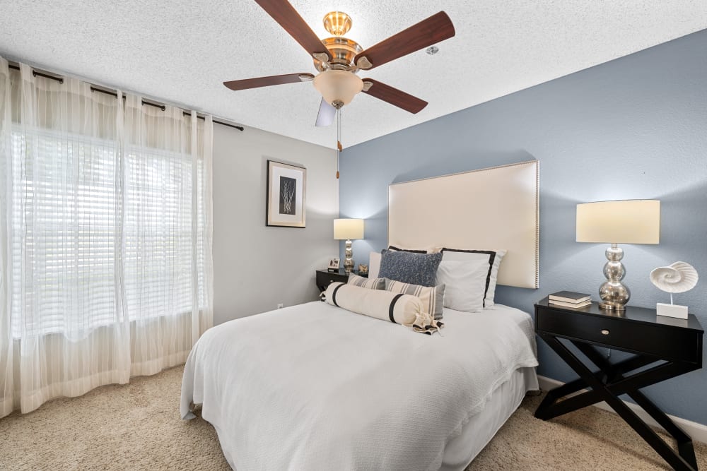 Spacious furnished bedroom with ceiling fan at The Hills of Corona in Corona, California