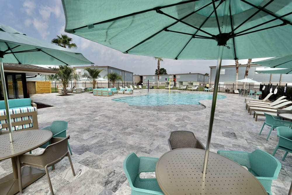 Lounge chairs near pool at Emerald Pointe Apartment Homes In Harvey