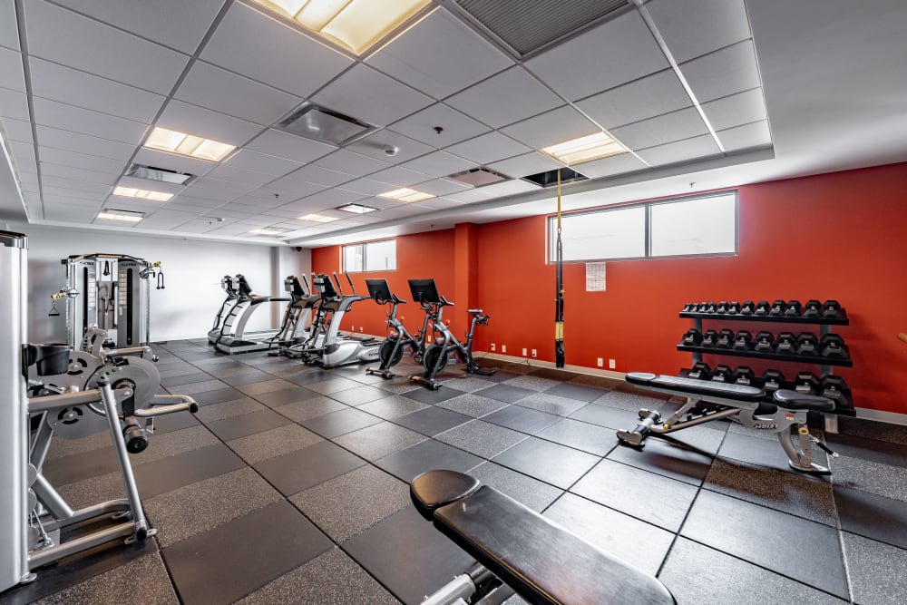 An orange wall and equipment in the fitness center at Front Street Lofts in Hartford, Connecticut