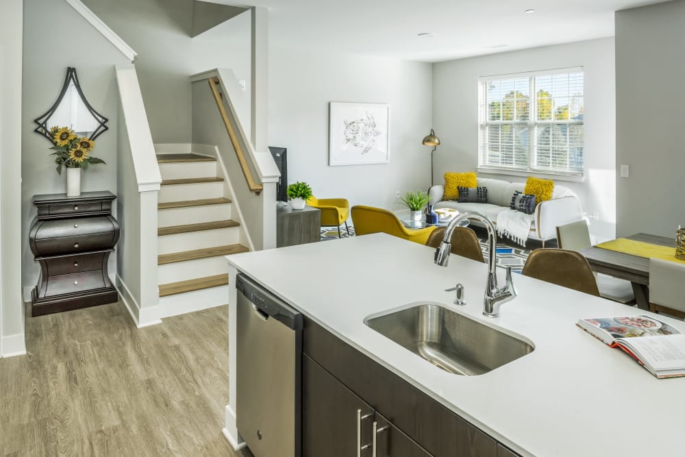 An apartment kitchen, living room and stairs leading to the townhomes bedrooms at Cove at Gateway Commons in East Lyme, Connecticut
