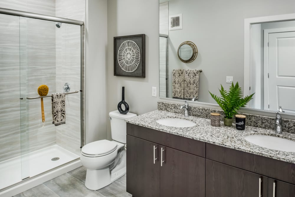 Dark wood cabinets and a full bathtub in a townhome bathroom at Cove at Gateway Commons in East Lyme, Connecticut