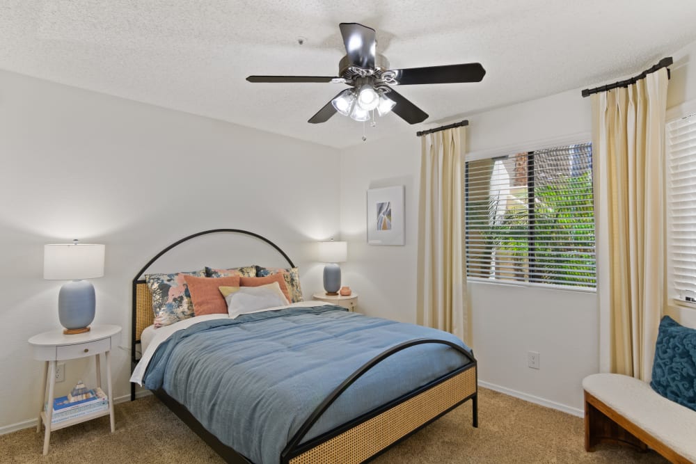 Bedroom with ceiling fan and large windows at Casa Santa Fe Apartments in Scottsdale, Arizona