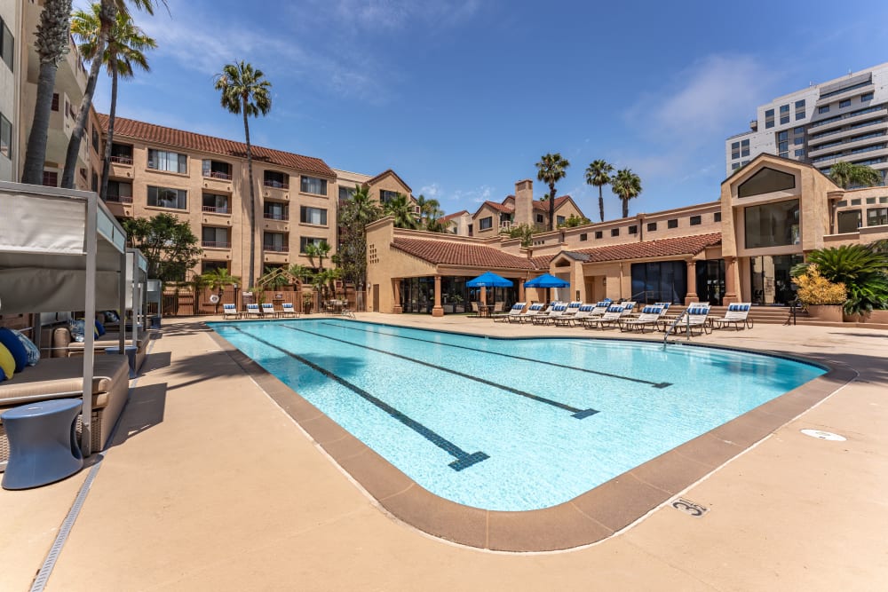 Large swimming pool in a sunny and spacious courtyard with comfortable lounge chairs around at Veranda La Jolla in San Diego, California