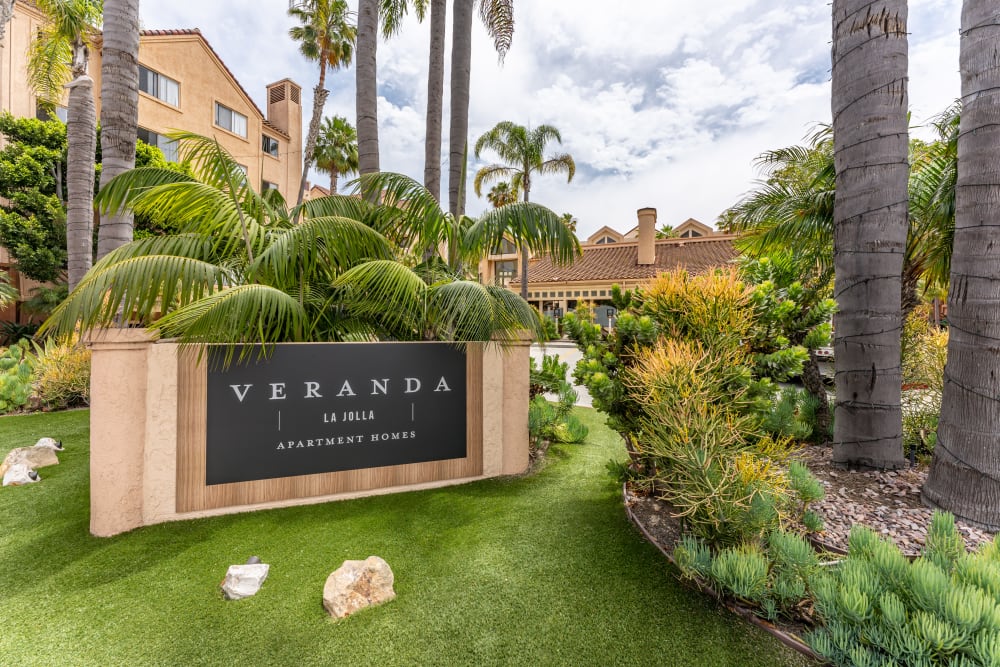 Monument entry sign with greenery surrounding it welcoming everyone to their new homes at Veranda La Jolla in San Diego, California