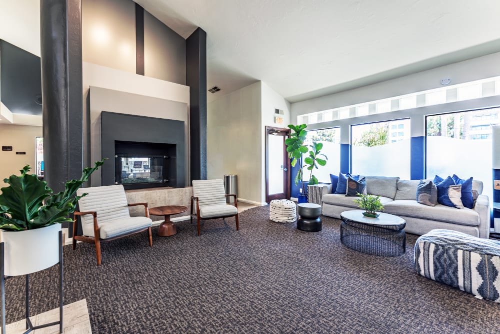 Spacious and modern clubhouse with a fireplace and large windows for residents to socialize at Veranda La Jolla in San Diego, California