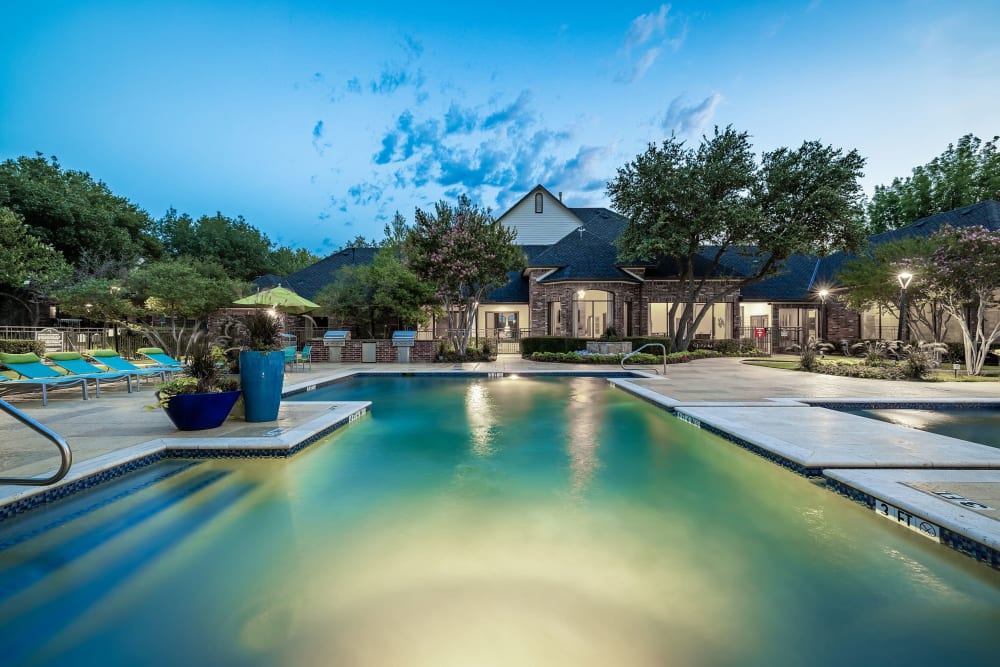 Resort-style Swimming pool at twilight at Marquis at Stonebriar in Frisco, Texas