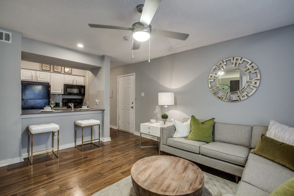 Wood flooring in a furnished living room with a ceiling fan at Verandahs at Cliffside Apartments in Arlington, Texas