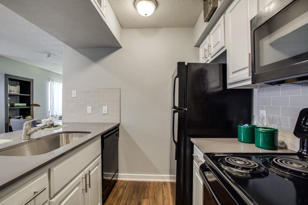 Black appliances in a model apartment kitchen at Verandahs at Cliffside Apartments in Arlington, Texas