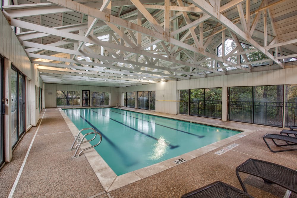 A large indoor pool with seating next to it at Verandahs at Cliffside Apartments in Arlington, Texas