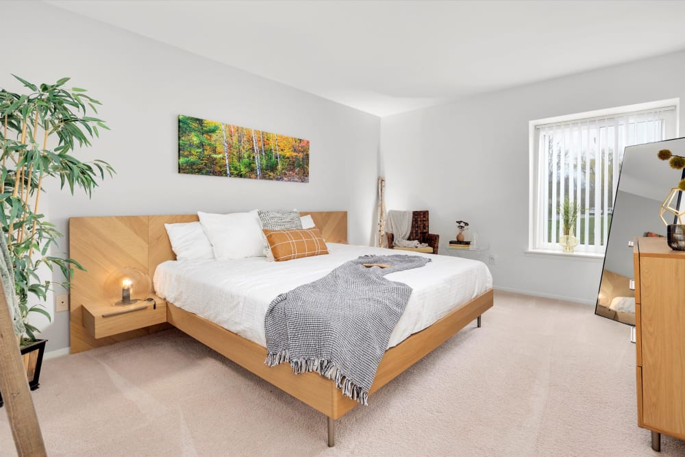 Large model bedroom with plush carpeting at Fairmont Park Apartments in Farmington Hills, Michigan