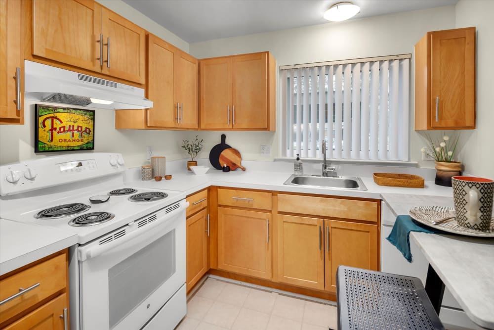 Fully equipped kitchen with white appliances at Fairmont Park Apartments in Farmington Hills, Michigan