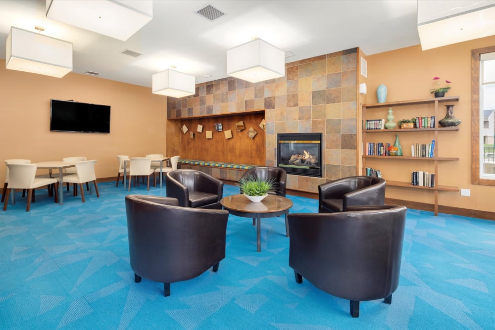 Common room with a gas fireplace and plenty of seating for work or relaxing at Fairmont Park Apartments in Farmington Hills, Michigan