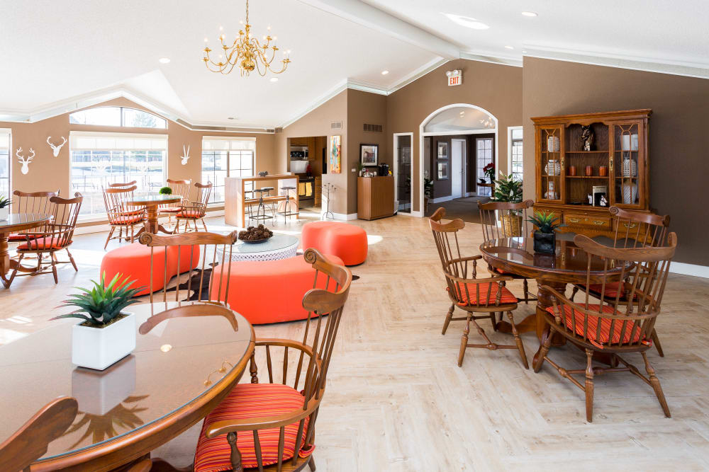 Resident clubhouse with plenty of tables for dining, work, or games at Saddle Creek Apartments in Novi, Michigan