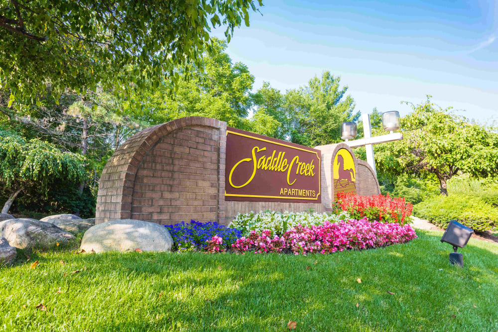 Sign and flowers at the entrance to Saddle Creek Apartments in Novi, Michigan