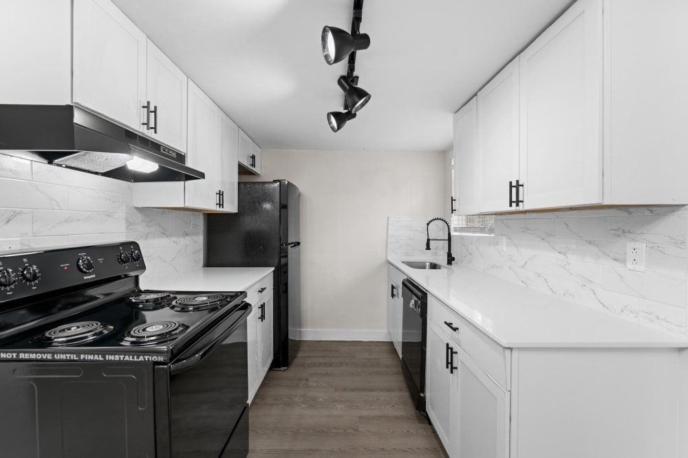 Black appliances and white cabinets in an apartment kitchen at Cobbs Creek Apartment Homes in Decatur, Georgia