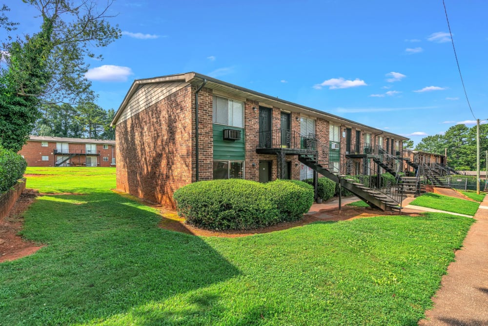 Exterior of an apartment building and manicured lawn at Cobbs Creek Apartment Homes in Decatur, Georgia