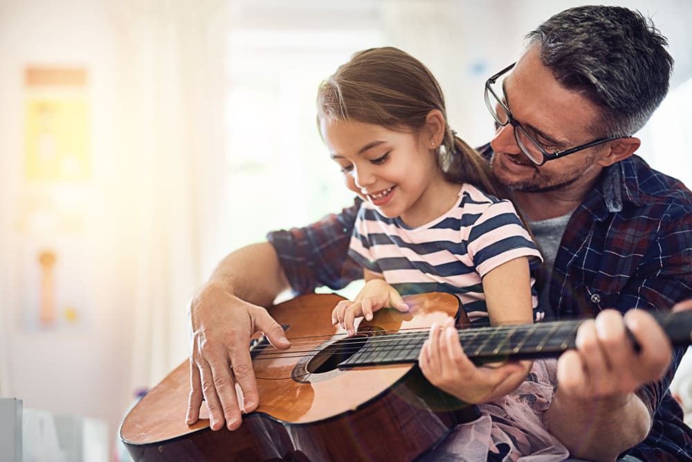 Resident father and daughter playing guitar together in their home at Delano in Redmond, Washington