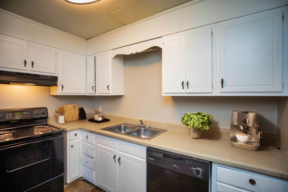 Black appliances and white cabinets in an apartment kitchen at Magnolia Manor Apartments in Center Point, Alabama