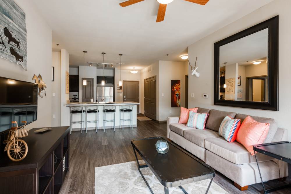 Spacious furnished living room with ceiling fan at The Quarters at Stillwater in Stillwater, Oklahoma