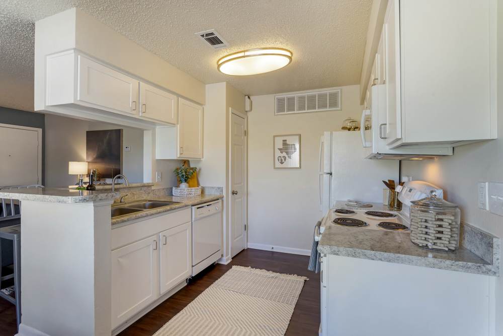 Apartment kitchen with hardwood floors and major appliances at The Landing at College Station in College Station, Texas