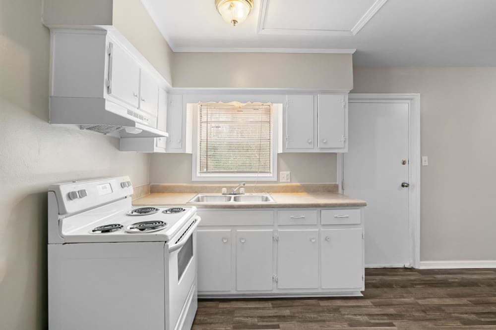 White cabinets and wood flooring in an apartment kitchen at Walnut Creek Apartments in Macon, Georgia