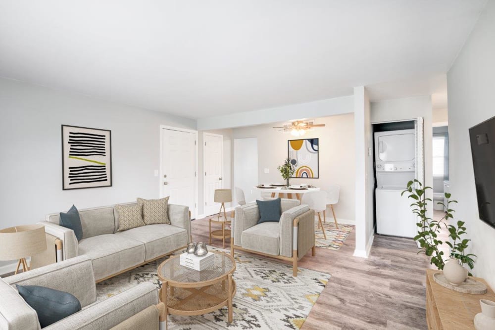 Staged living room with in-unit laundry and vinyl plank floors