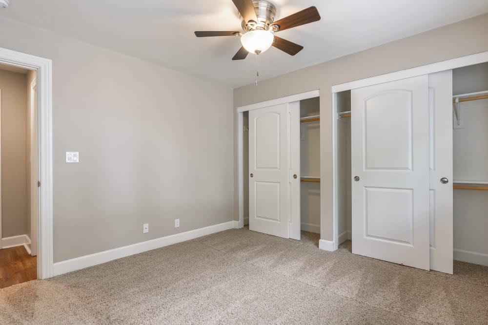Bedroom with push carpeting, large closets, and a ceiling fan at Pentagon Apartments in Fremont, California