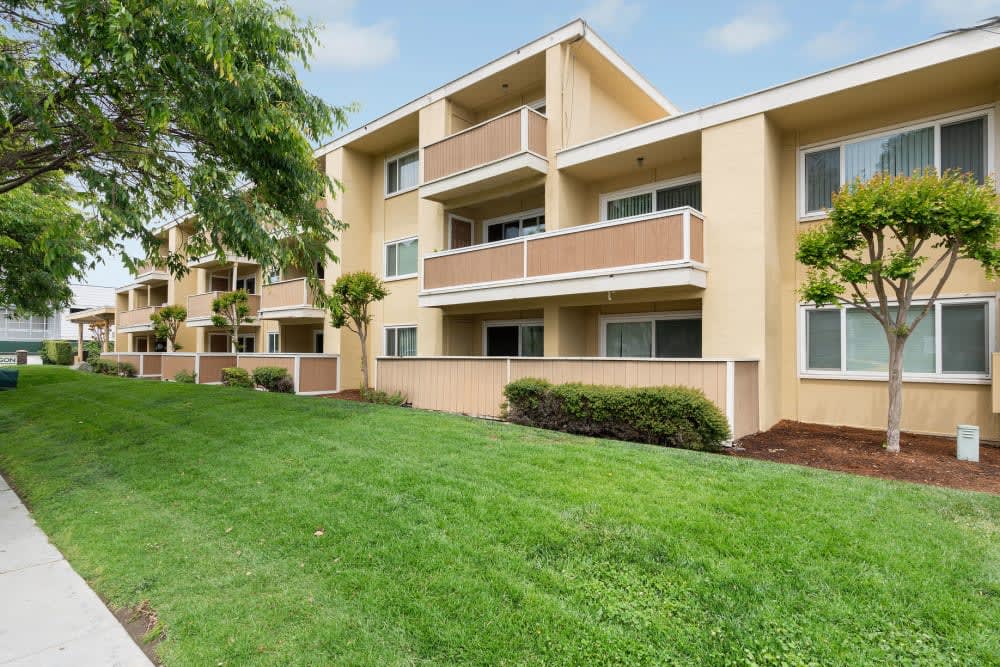 Apartment building exterior and well-manicured lawn at Pentagon Apartments in Fremont, California