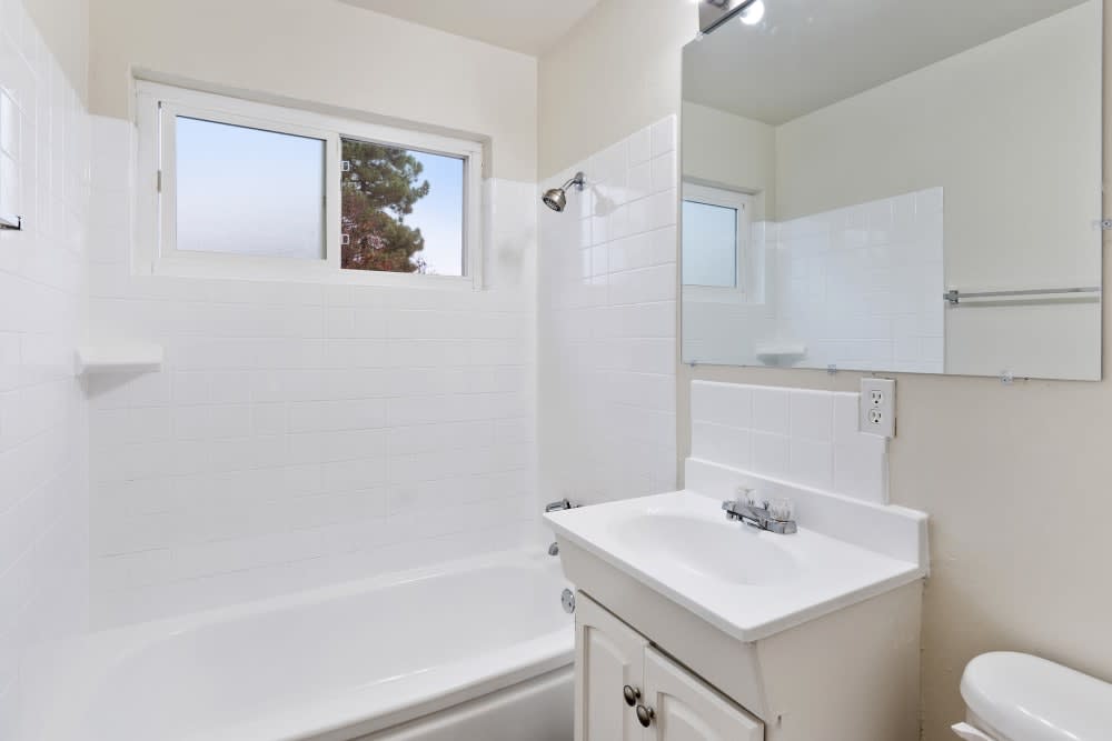 Bathroom with tiled tub/shower combination and oversized mirror at Parkway Apartments in Fremont, California