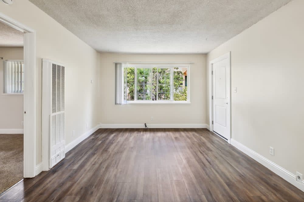 Spacious living room with wood-style flooring at Parkway Apartments in Fremont, California