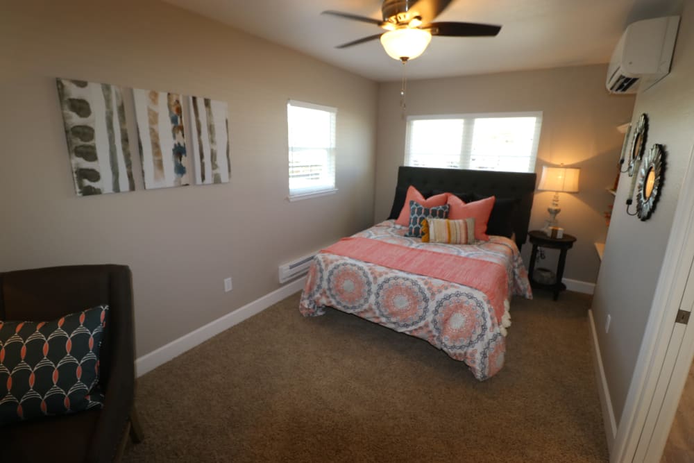 Spacious model bedroom with a ceiling fan and plush carpeting at Ramblewood Apartments in Fremont, California