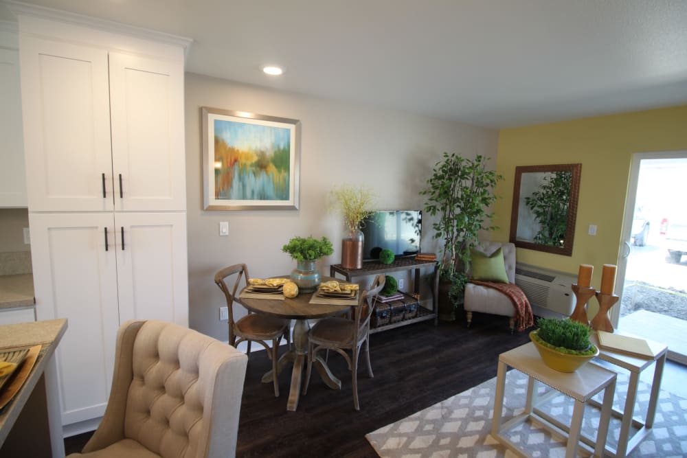 Living room and dining area with a bistro table in a model apartment at Ramblewood Apartments in Fremont, California
