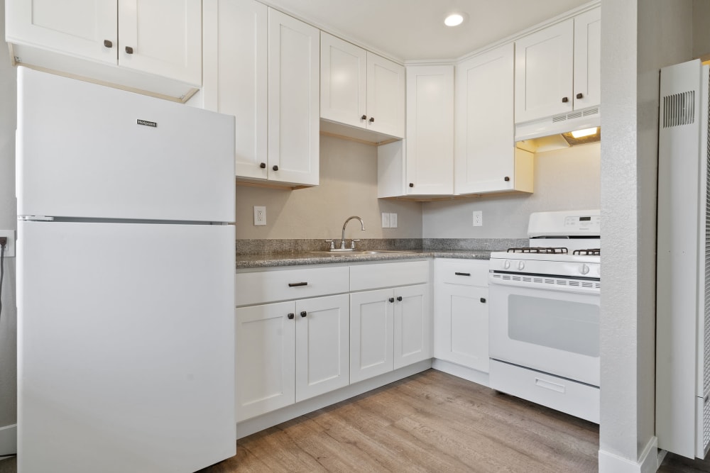 Fully equipped kitchen with upgraded appliances and white cabinetry at Royal Gardens Apartments in Livermore, California