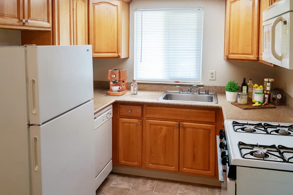 Kitchen with white appliances at Alderwood Park Apartments in Livermore, California
