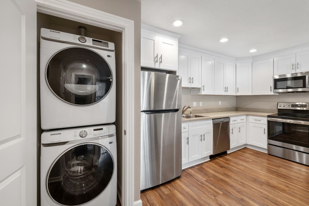 Stacked washer and dryer next to the kitchen of an apartment home at Vista Creek Apartments in Castro Valley, California