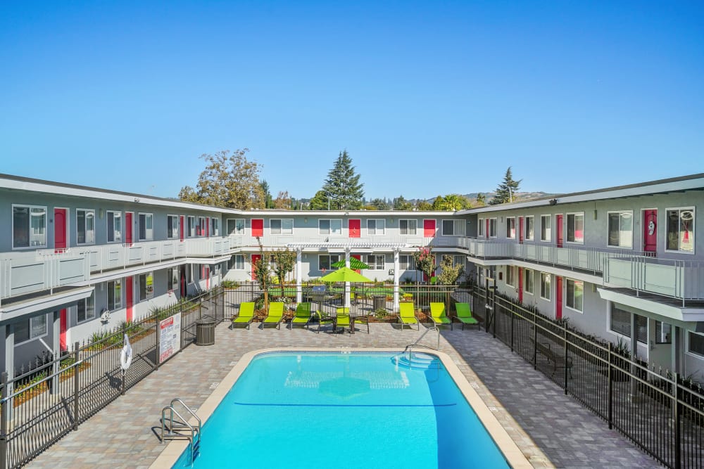 Sparkling pool surrounded by private patios at Bon Aire Apartments in Castro Valley, California