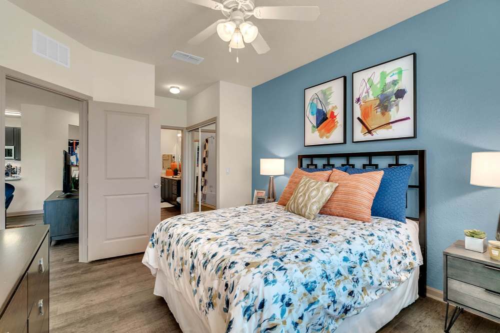 Furnished apartment bedroom with fullsize bed and throw pillows at Art Avenue Apartment Homes in Orlando, Florida