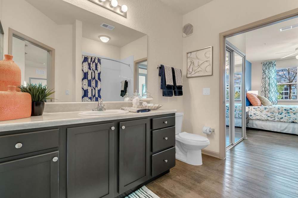 Apartment bathroom with large mirror and vanity at Art Avenue Apartment Homes in Orlando, Florida
