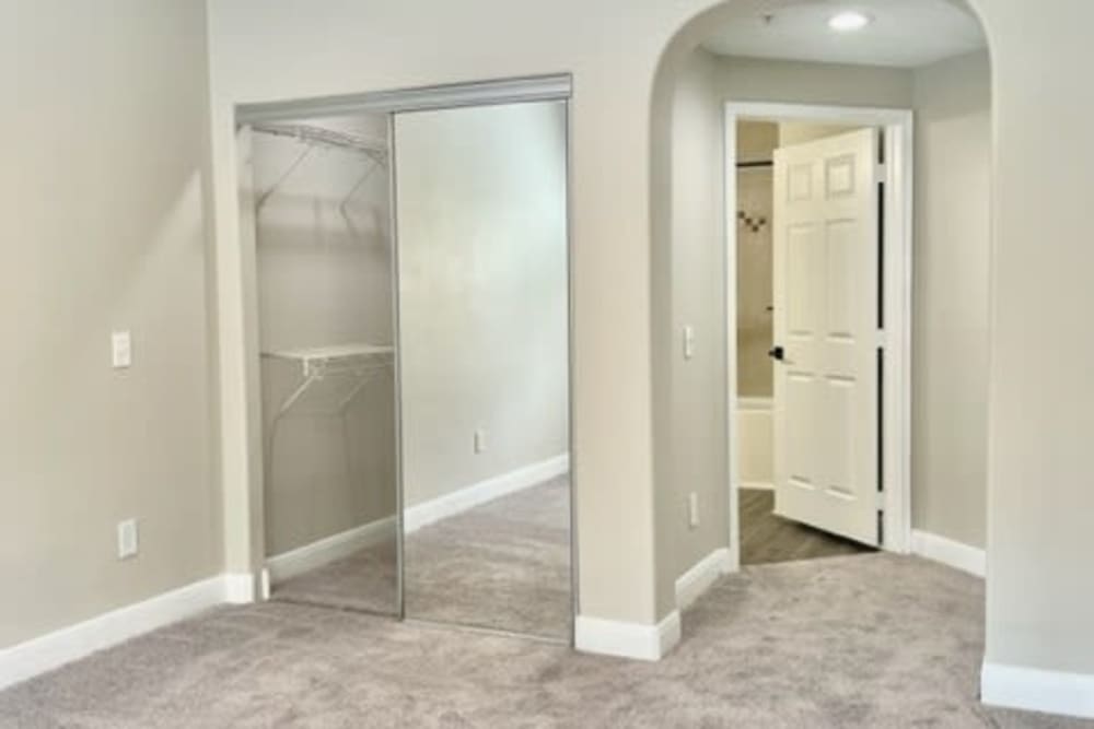 Apartment bedroom with a walk in mirror closet at The Margot on Sage in Houston, Texas