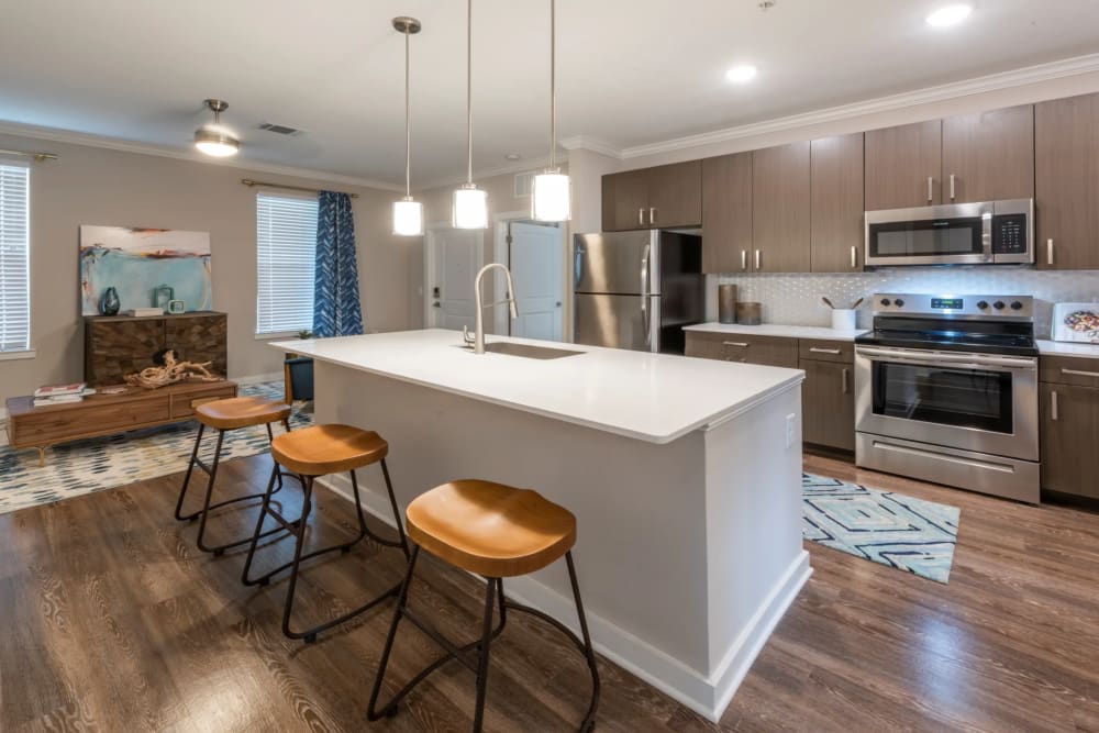 Kitchen with large island and stainless-steel appliances at Verso Luxury Apartments in Davenport, Florida