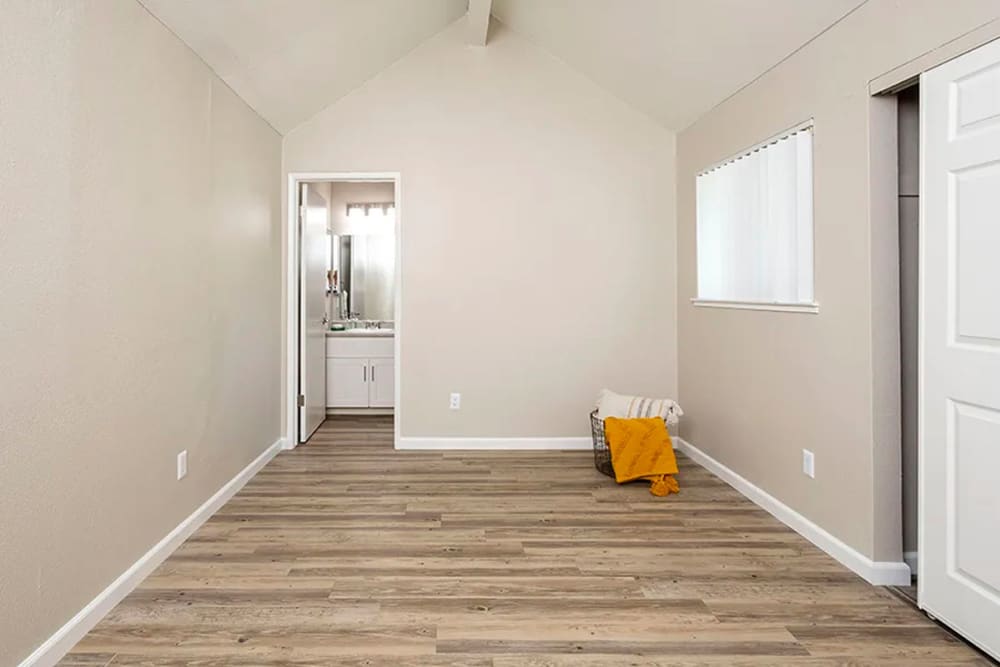 Spacious bedroom with wood-style flooring at Americana Apartments in Rohnert Park, California