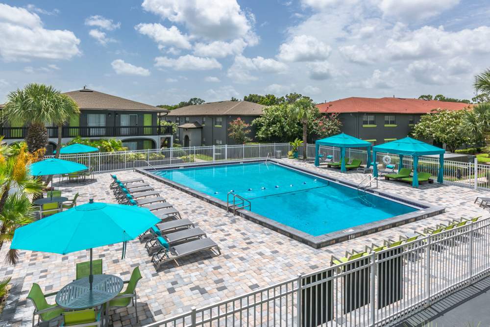 Inground pool with multiple lounge chairs and seating at Central Place at Winter Park in Winter Park, Florida