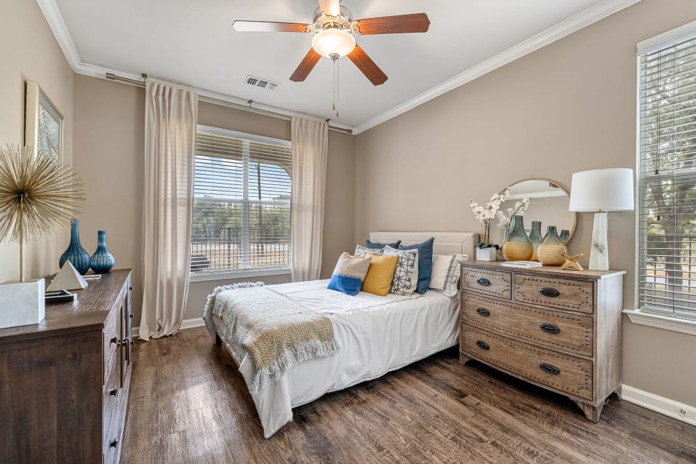 Bright bedroom with wood floors and a ceiling fan at Marquis at Crown Ridge in San Antonio, Texas